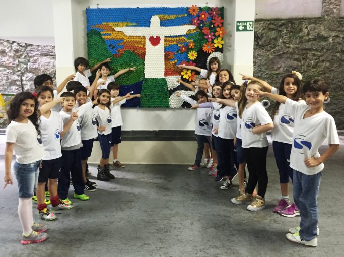 Alunos do 2º ano posam na frente do quadro O Rio de Janeiro continua lindo.